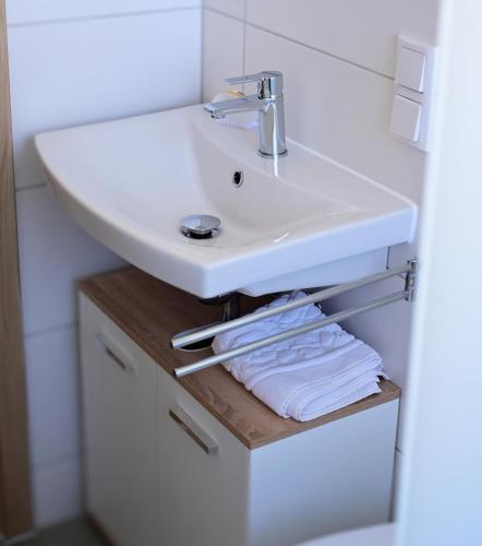 a bathroom with a white sink and some towels at Ferienwohnung Zum Steiger in Bleicherode