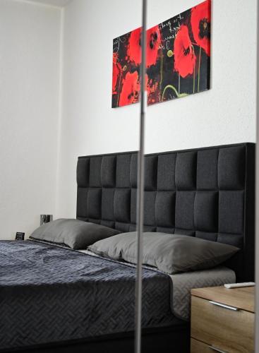 a bedroom with a bed with a black headboard at Ferienwohnung Zum Steiger in Bleicherode