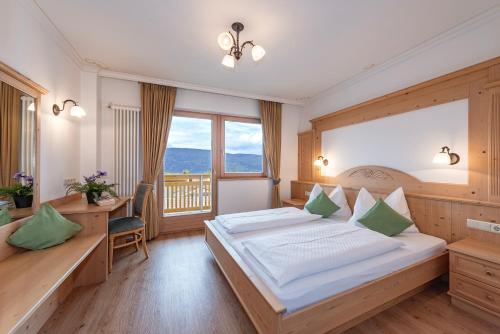 a bedroom with a bed and a desk and a window at Residence Diana Apartment 301 in Terento