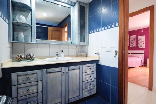 a bathroom with a sink and a bedroom at Casa Las Cañas in Icod de los Vinos