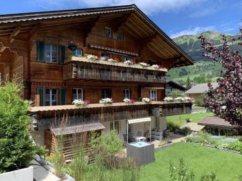 a large wooden house with flowers on the balcony at Apartment Chalet Nussknacker by Interhome in Lenk