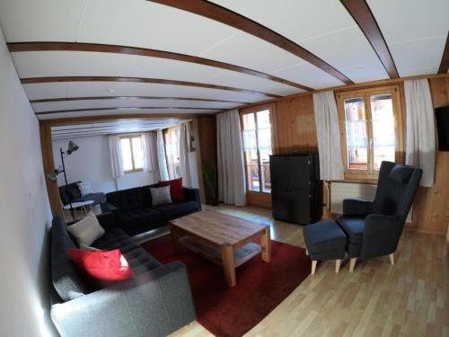 a living room with a couch and a table at Apartment Chalet Nussknacker by Interhome in Lenk