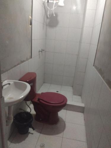 a bathroom with a red toilet and a sink at Casa de huespedes en el centro in Cajamarca
