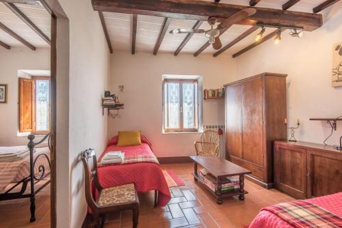 a bedroom with two beds and a table in a room at Casa Francesca in Montalcino