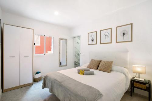 a white bedroom with a large white bed in it at El Ramonal Vacacional in Candelaria