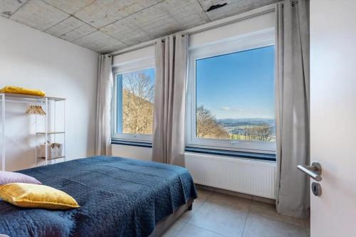 a bedroom with a bed and a large window at Suiten im Alten Berghotel Franziska in Eslohe