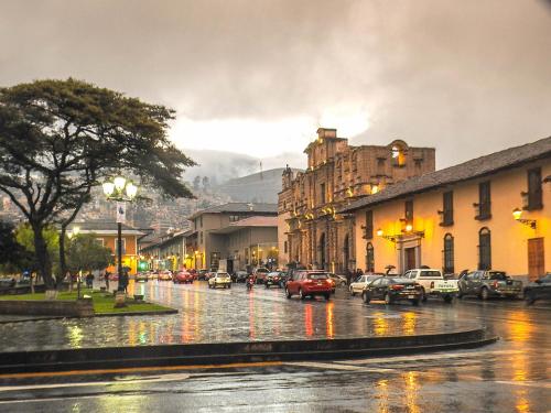 a city street in the rain with cars parked at Casa de huespedes en el centro in Cajamarca