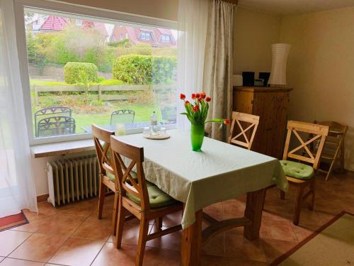 a dining room table with a vase of flowers on it at Ferienwohnung Schmidt Haffkamp in Grömitz