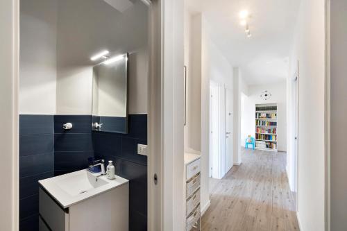 a bathroom with a white sink and blue tiles at Il Borgo Incantato con garage in Finale Ligure