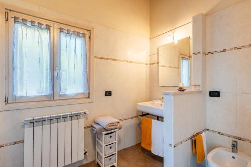 a white bathroom with a sink and a mirror at Residence Al Pozzo in Capannori