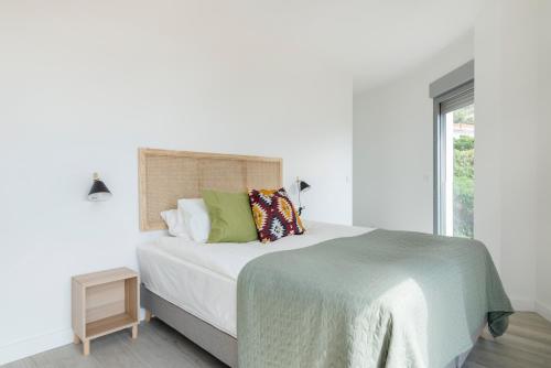 a white bedroom with a bed and a window at Central Apartment with a view in Mijas