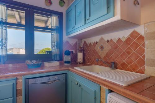 a kitchen with blue cabinets and a sink at La Terrazza sul mare in Palau
