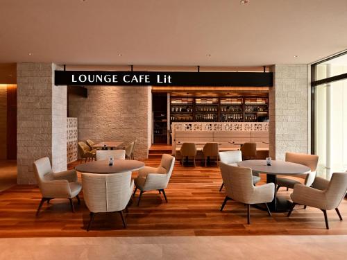 a lobby of a lounge cafe with tables and chairs at Lit Hotel NAKIJIN in Nakijin