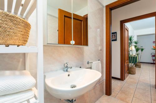 two pictures of a bathroom with a sink and a mirror at Home Centrum 2 in Giarre