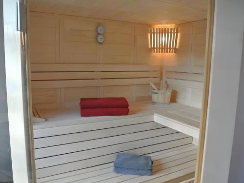 a sauna with a red seat in a wooden room at Kleines Landhaus in Herbstein