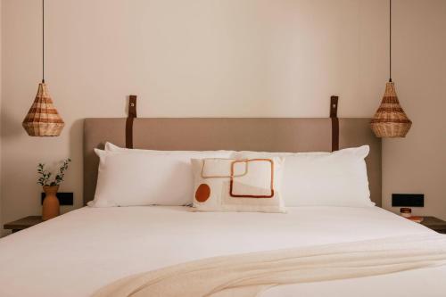 a bedroom with a white bed with white pillows at Zel Costa Brava in Tossa de Mar