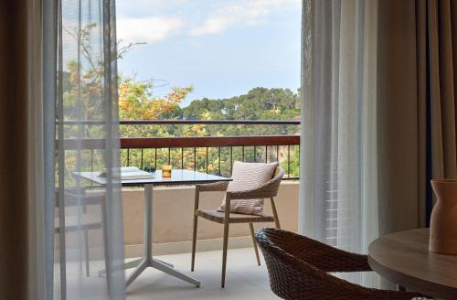 a balcony with a table and chairs and a window at Zel Costa Brava in Tossa de Mar