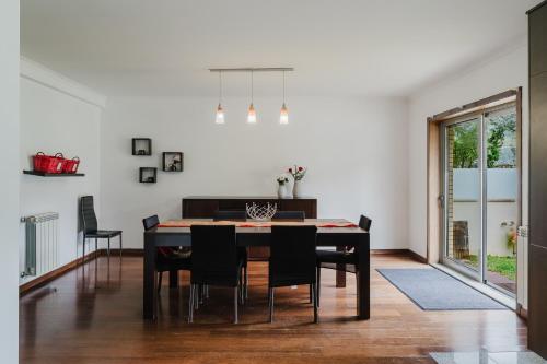 a dining room with a black table and chairs at Paradise Villa in Esposende