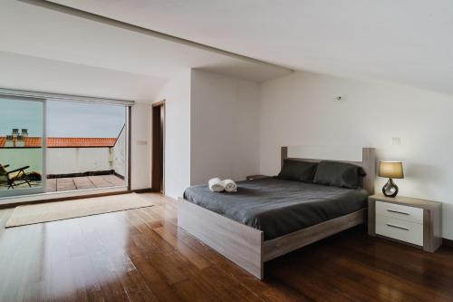 a bedroom with a bed and a large window at Paradise Villa in Esposende