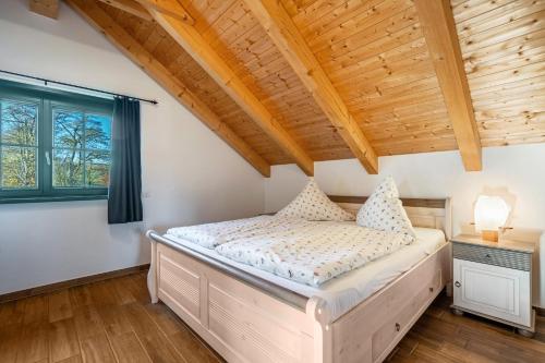a bedroom with a bed and a wooden ceiling at Blockhaus - Ferienwohnung Sunset in Erdmannsdorf