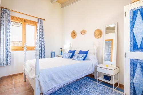 a bedroom with a white bed and blue curtains at Son Amanada in Santa Margalida