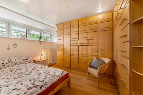 a bedroom with a bed and a chair at Heimatglück Vulkaneifel mit Sauna in Salm