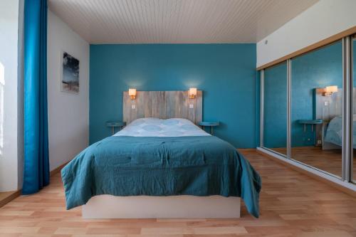 a blue bedroom with a bed with blue walls at Kervalou in Sainte Anne d'Auray