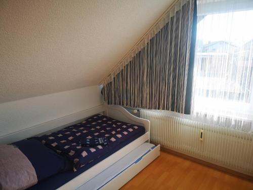 a small bed in a room with a window at Ferienwohnung Eckert in Wehr