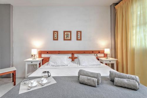 a bedroom with a large white bed with two chairs at Apartamento Retama in Adeje