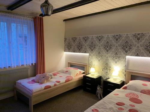 a bedroom with two beds and a cat sitting between them at Ferienwohnung Bullentäle in Albstadt