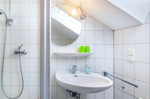 a white bathroom with a sink and a mirror at Vronis Ferienwohnungen in Mühlingen