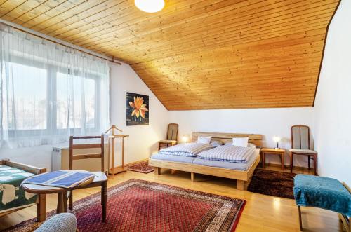 a bedroom with two beds and a wooden ceiling at Vronis Ferienwohnungen in Mühlingen