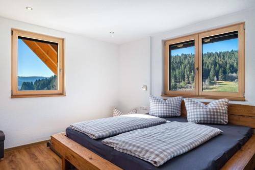a bedroom with two beds and two windows at Gantershof in Titisee-Neustadt