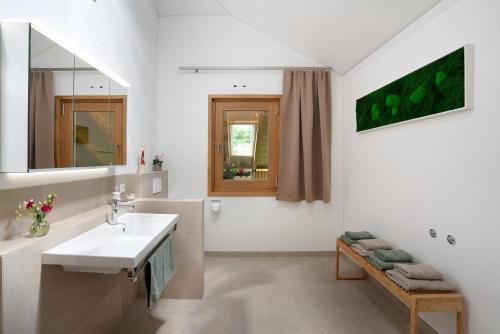 a white bathroom with a sink and a mirror at Ferienwohnung Marie in Egling