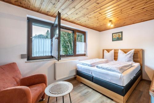 a bedroom with a bed and a couch and a chair at Am Wehrastrand App Eg in Todtmoos