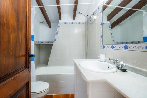a bathroom with a sink and a toilet and a tub at Villa Piedra in Pollença