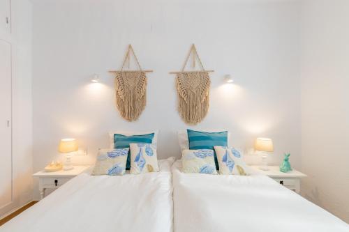 a bedroom with two beds with blue pillows at El Pinito Moraira in Moraira