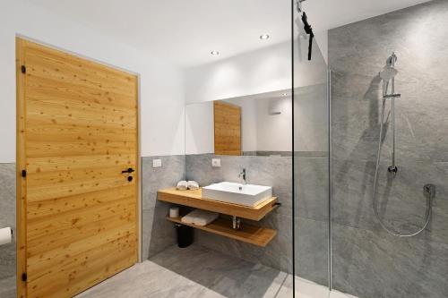 a bathroom with a sink and a shower at Pfaffingerhof Antholz in Masserie