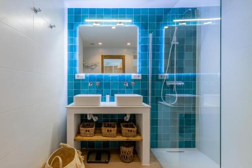 a blue tiled bathroom with two sinks and a shower at El Pinito Moraira in Moraira