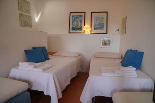 a room with three beds with blue pillows at Casa Annamaria in Arcola