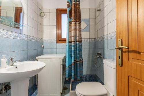 a bathroom with a sink and a toilet and a shower at Moraki Apartment 1 Andros in Korthi