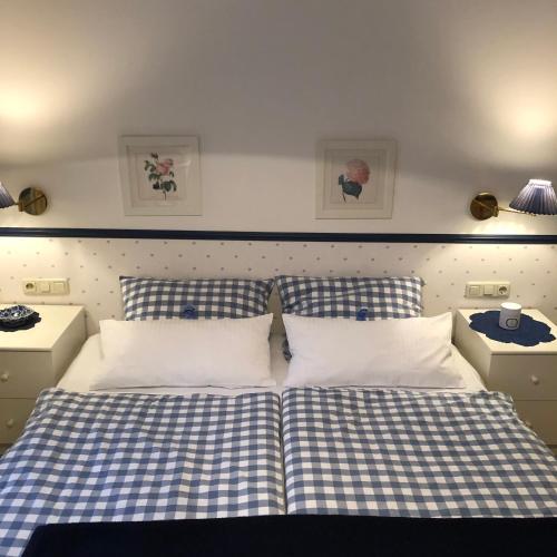 a bedroom with two beds with blue and white sheets at Ferienwohnung im Burghotel in Aschau im Chiemgau