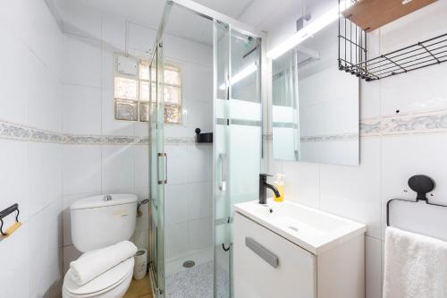 a white bathroom with a toilet and a sink at Vista al Mar Ylenia in Almería