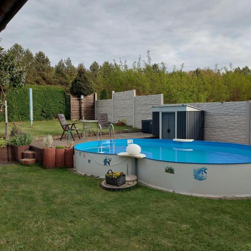 a small swimming pool in a yard with a table at Ferienwohnung in Spreewaldnähe in Kolkwitz