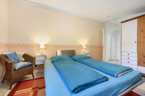 a bedroom with a large bed with blue sheets at Ferienwohnung Rosenrot in Überlingen
