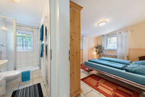 a bedroom with a bed and a bathroom with a tub at Ferienwohnung Rosenrot in Überlingen