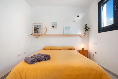 a bedroom with a bed with two towels on it at Casa Maracuya in Tarifa