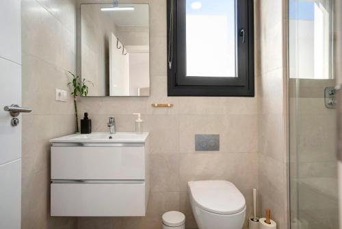 a bathroom with a toilet and a sink and a mirror at Casa Maracuya in Tarifa