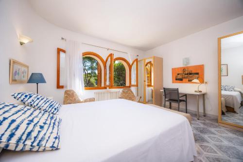 a bedroom with a large white bed and a desk at Ca Ses Mestres in Santanyi
