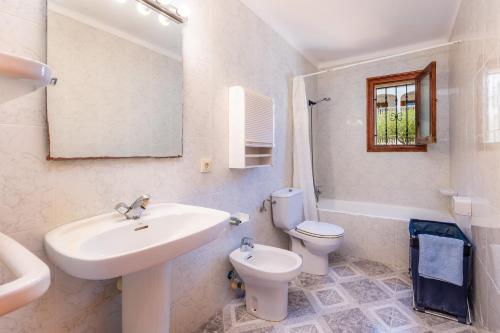 a bathroom with a sink and a toilet and a mirror at Ca Ses Mestres in Santanyi